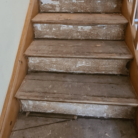 Vorher-Nachher-Vergleich: Alte Holztreppe vor der Verkleidung.